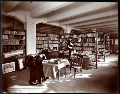 Woman and a young man in a library of the Museum of Safety Appliances of the American Institute of Social Service, New York by Byron Company